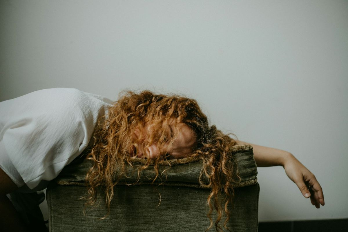 Pessoa cansada com a cabeça apoiada nos braços depois de um dia de trabalho